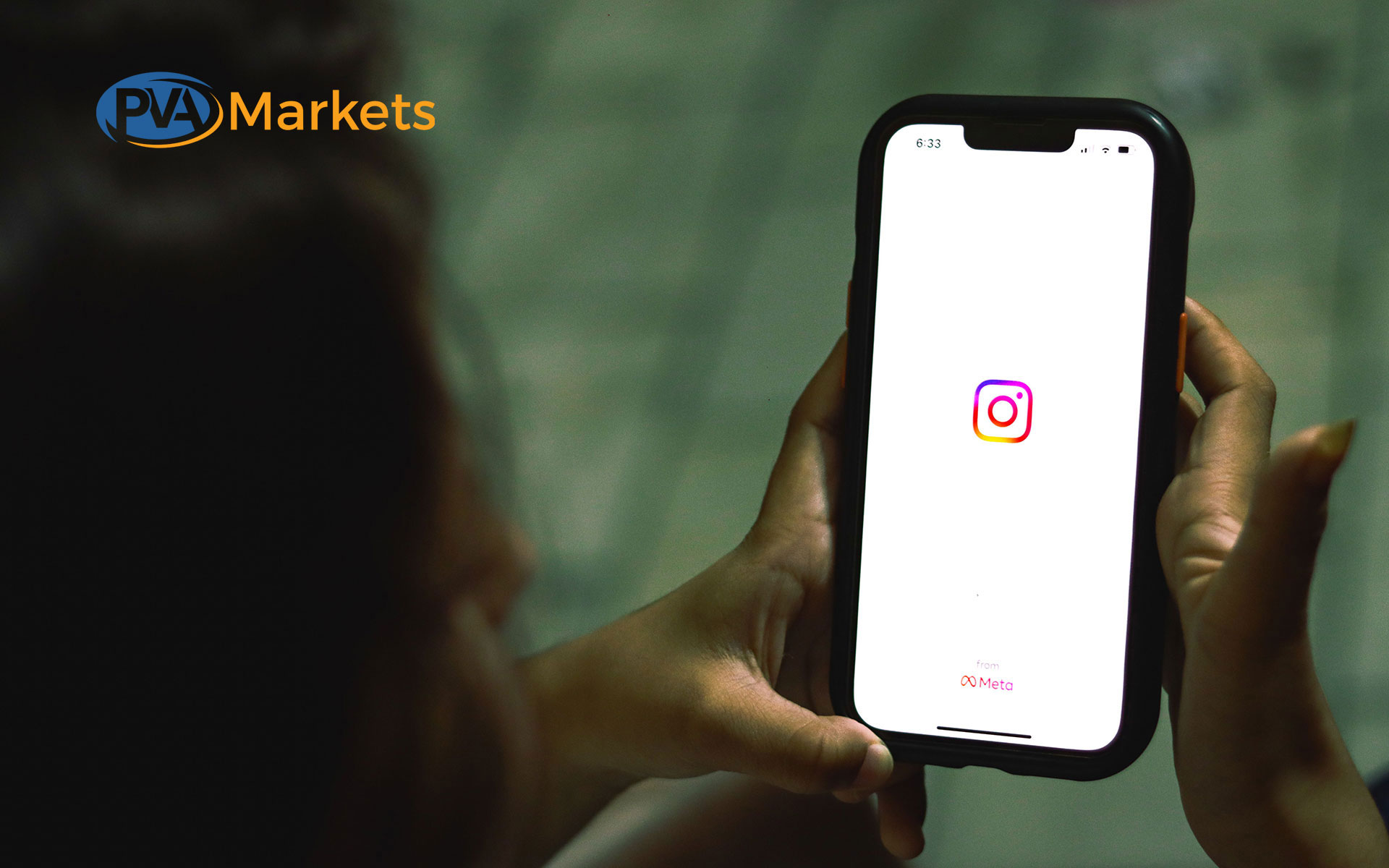 Hand holding a smartphone displaying the Instagram app icon